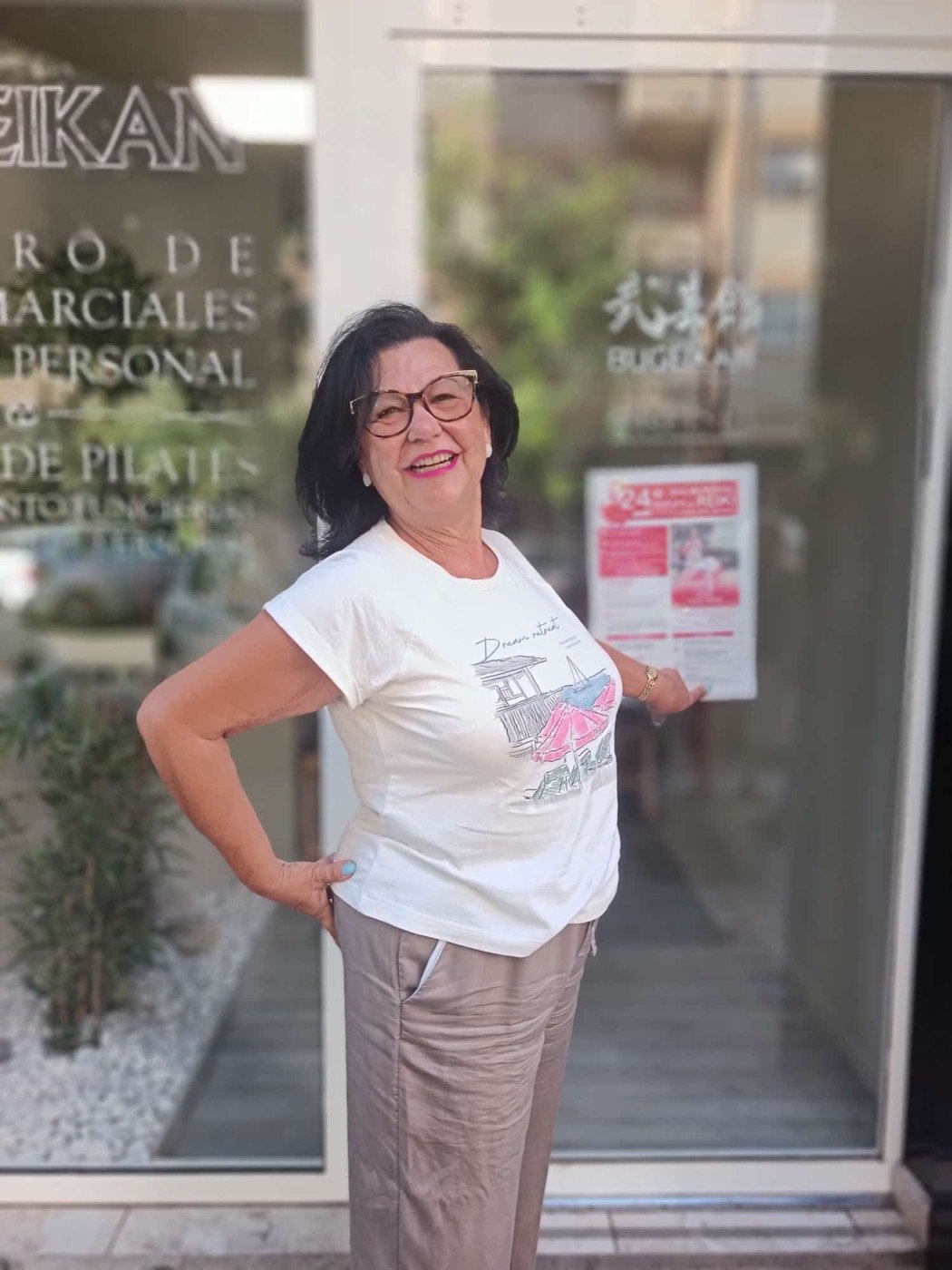 Charo Moñino junto al cartel del Día Mundial del Reiki en la entrada del centro Bugeikan de Valencia